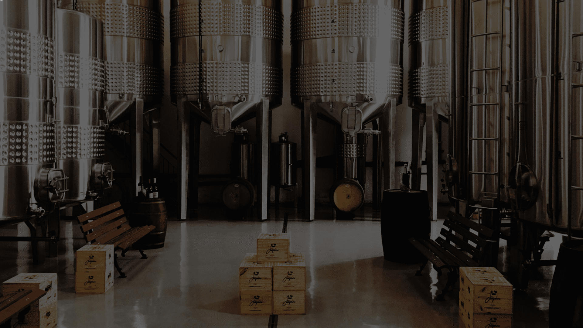 A warehouse filled with brewery tanks and crate boxes stacked in the center