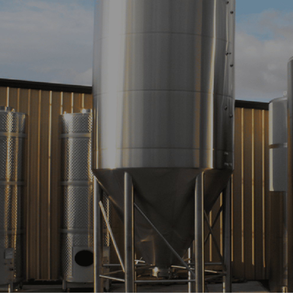 Wine brewery tank outside in front of a fence